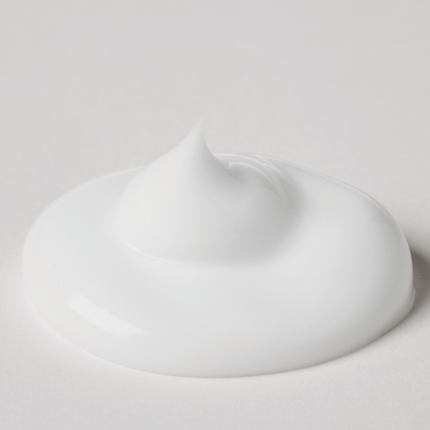 Feuchtigkeitscreme - Hydrating Luminizer in weißer, cremiger Konsistenz auf einem neutralen Hintergrund.